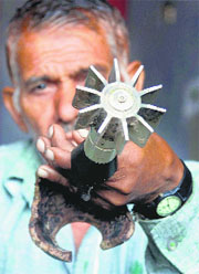 A man displays a part of a mortar shell.