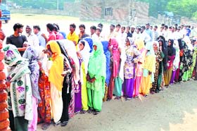 Voters queue up outside a polling booth in Ferozepur Jhirka on Saturday