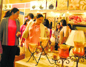 Visitors admire lamp-shades at a stall