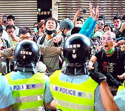  Protesters jeer and yell at police officers in the Mongkok district of Hong Kong on Saturday.