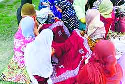 Helping hand: Girls stitch pherans for flood victims in Budgam district