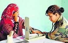An Army doctor examines a woman at a medical camp in Baramulla district on Sunday