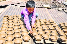 Light touch: A boy places earthen lamps in the sun to dry ahead of Diwali in Jammu on Monday