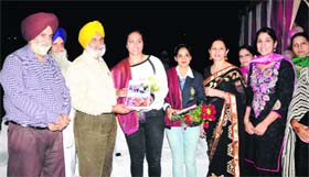 KCGC honorary secretary Rajinder Mohan Singh Chhina felicitates Khalsa College athletes Khushbir Kaur and Navjit Kaur Dhillon in Amritsar on Tuesday.