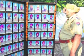 A police official salutes at a wreath laying ceremony to martyrs on the occasion of Police Commemoration Day in Amritsar on Tuesday.