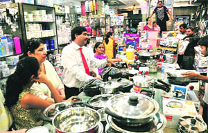 People buy utensils on the occasion of Dhanteras at a shop in Sector 20, Chandigarh, on Tuesday
