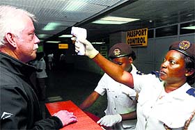 A health worker uses a thermal scanner at Lagos airport.