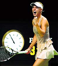 Caroline Wozniacki celebrates her win over Maria Sharapova at the WTA Finals in Singapore on Tuesday