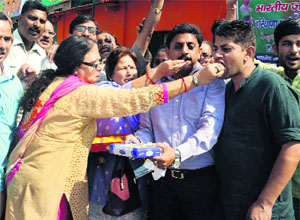BJP workers celebrate the victory of the party in the Maharashtra and Haryana elections in Dehradun on Monday.