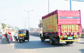 An auto-rickshaw negotiates a turn while coming from the wrong side on the elevated road in Amritsar.