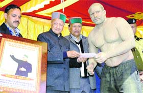 Chief Minister Virbhadra Singh gives away prizes during the concluding ceremony of Wrestling (Chinj) Championship at Kotkhai in Shimla on Wednesday