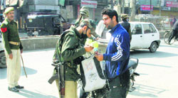 A security personnel checks the bag of a man in Srinagar on Wednesday. Tribune Photo: Yawar Kabli