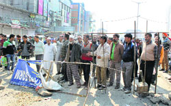 Shopkeepers block the main road near Exhibition Crossing in Srinagar on Wednesday. Photo: Yawar Kabli