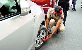a cop locks a wrongly-parked vehicle in Ludhiana on Wednesday.
