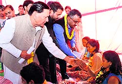 Hira Singh Bisht, Congress legislator, offers juice to a protesting unemployed trainer in Dehradun 