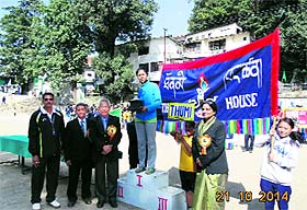 The chief guest presents the winning trophy to students during the annual sports day of Central School of Tibetans in Mussoorie on Tuesday. 