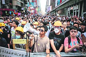 Pro-democracy demonstrators guard a barricade in the Mongkok district of Hong Kong on Wednesday. 