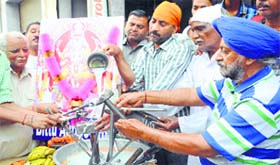 Mechanics wash their tools with milk on Visvakarma Day in Amritsar on Friday.