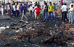 Residents try to salvage their belongings after a fire broke out at a slum cluster at Shastri Park in East Delhi on Friday