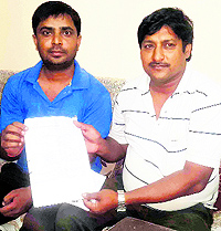 Rajesh Chautala (right) shows the inflated electricity bill at Gohana on Thursday