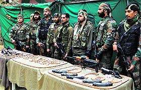 Army personnel display arms and ammunition recovered from a militant hideout in Kupwara district on Friday.