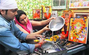 Automobile workshop owners wash their tools with milk on the occasion of Vishvakarma Day in Jalandhar on Friday