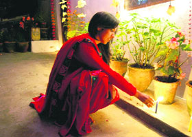 A girl lights candles on the eve of Diwali in Mussoorie on Thursday.