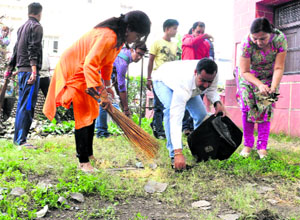 BJYM activists take part in a cleanliness drive at Clock Tower in Dehradun on Friday.