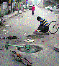 As a lineman of the BSNL moves inside a manhole for laying telecom lines, a fan is used to ensure circulation of air inside the manhole in Jalandhar on Saturday