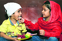 A sister offers sweets to her brother on the occasion of Bhaiya Dooj in Jalandhar on Saturday