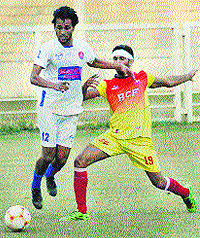 Players of RCF (yellow) and Punjab Police (white) try to take possession of the ball during the semi-final match of the 28th JCT Punjab State Super Football League 2014-2015 in Jalandhar on Saturday