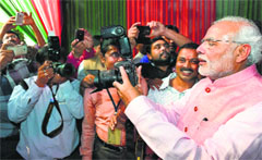 Prime Minister Narendra Modi clicks photographs at the BJP headquarters in New Delhi on Saturday. PTI 