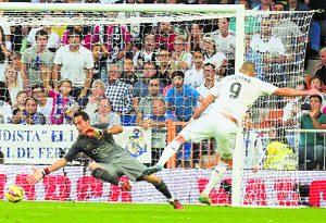 Real Madrids Karim Benzema scores his teams third goal against Barcelona during their La Liga match in Madrid on Saturday.