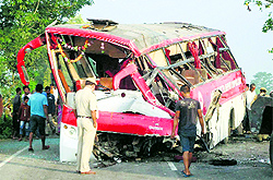 A policeman inspects the bus which met with an accident in Nagaon district of Assam on Sunday