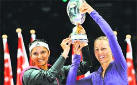 Sania Mirza and Cara Black of Zimbabwe hold the Martina Navratilova Trophy after defeating Su-Wei Hsieh of Taiwan and Shuai Peng of China in the doubles final of the WTA Finals in Singapore on Sunday.