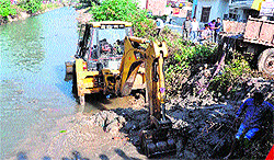 A JCB machine removes filth and garbage from the Ganga canal at Kankhal in Haridwar on Sunday
