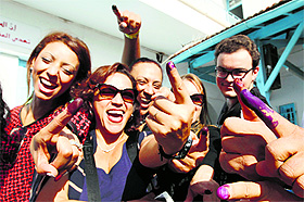 Tunisians show their ink-stained fingers in Tunis on Sunday. 