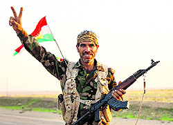 A member of the peshmerga forces gestures in Zumar after Kurdish forces retook Iraqi town from Islamic State.
