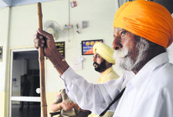 People wait outside the SSPs office at the District Administrative Complex in Bathinda on Monday. A TRIBUNE PHOTO