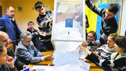 Members of the electoral commission empty a ballot box after voting day in Kiev on Sunday. Reuters
