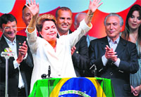 Re-elected Brazilian President Dilma Rousseff (C) waves following her win in Brasilia on Sunday. AFP