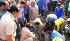 Local residents help pull out labourers who were buried under the debris of a wall in the Jandiala Guru area in Amritsar on Tuesday.