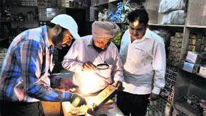 Fingerprint experts examine the crime spot where cigarettes worth Rs 15 lakh were stolen in Bathinda on Tuesday.