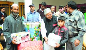 Shiva Gopal Mishra, general secretary, All India Railwaymens Federation, distributes relief among the flood-affected in Budgam.