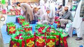 Students of Darul Uloom Raheemiya in Bandipora prepare packets of relief material for flood victims.