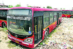 A fleet of buses parked in an open area. a file photo