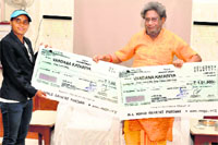 Indian national hockey player Vandana Kataria being given a cheque for Rs 2.51 lakh by Gayatri Shantikunj family head Dr Pranav Pandya at Shantikunj in Haridwar on Tuesday. Tribune photo