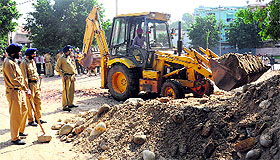 A JCB machine removes encroachments at Madanpura village in Mohali. 