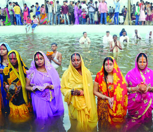Devotees offer prayers to the sun on the occasion of Chhath Puja in New Delhi on Wednesday.
