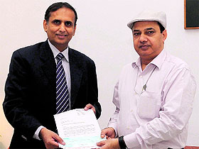 A Bridgestone official hands over a cheque for ~1 crore to Pradeep Kumar Bali, Under Secretary (Funds), PMO, for flood victims of Jammu and Kashmir. 